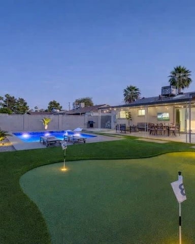 Backyard pool and putting green at dusk at a Desert Pine Stays home in Scottsdale
